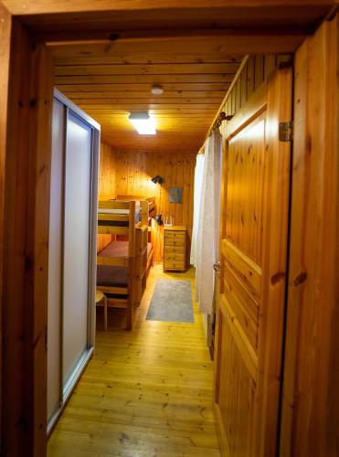 a hallway in a room with wooden walls and a bedroom at Paimentupa Majavaranta-mökki in Yläkoli
