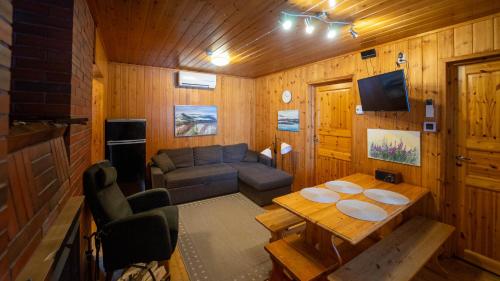 a living room with a couch and a table at Paimentupa Majavaranta-mökki in Yläkoli