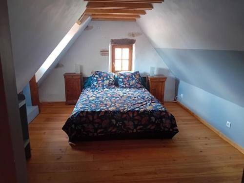 une chambre avec un lit dans un grenier dans l'établissement Maison Typique Lotoise Saint Cirq Lapopie, à Saint-Cirq-Lapopie