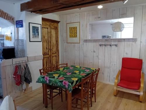 une cuisine avec une table et des chaises dans une pièce dans l'établissement Maison Typique Lotoise Saint Cirq Lapopie, à Saint-Cirq-Lapopie