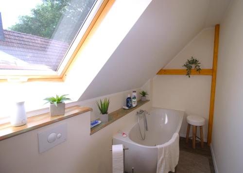 ein Badezimmer mit Badewanne und Fenster in der Unterkunft Seweko - Ferienhaus am Donnerberg - Kamin & Küche in Wittstock