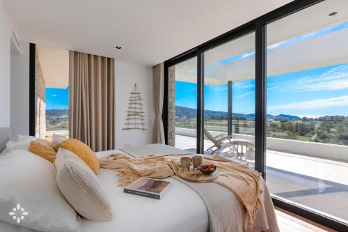 a bedroom with a white bed with a large window at Villa Avalon by Abahana Luxe in Benitachell