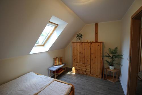 Schlafzimmer im Dachgeschoss mit einem Bett und einem Fenster in der Unterkunft Seweko - Ferienhaus am Donnerberg - Kamin & Küche in Wittstock