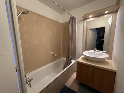 a bathroom with a sink and a tub and a mirror at Adour e vita in Pontonx-sur-lʼAdour