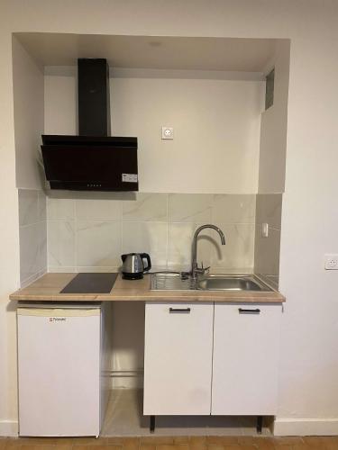 a small kitchen with a sink and a microwave at Studio - à 1min du metro 8 mai 1945 - ligne 7 - 20 min d'Opéra Garnier in La Courneuve