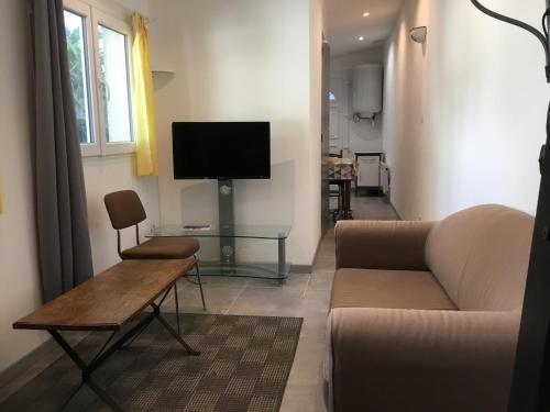 un salon avec un canapé et une télévision dans l'établissement Maisonette bedogao, à Valence