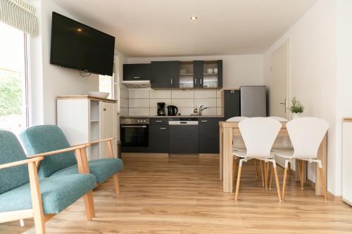 a kitchen with a table and chairs in a room at Bungalows Ostseequelle in Hohenkirchen