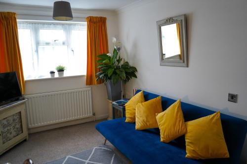 a blue couch with yellow pillows in a living room at Waterside Park Annex in Kingsbridge