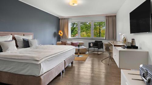 a hotel room with a large bed and a desk at Hotel Central in Hof