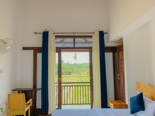 Un dormitorio con una cama y una ventana grande. en Kadalla Holiday Resort, en Rambukanagama