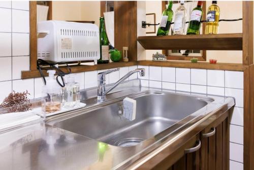 a stainless steel sink in a kitchen with bottles at アンティークス岐阜関 Antiques Gifu Seki in Sekimachi