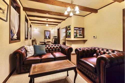 a living room with two leather couches and a table at アンティークス岐阜関 Antiques Gifu Seki in Sekimachi