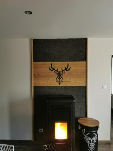- une cheminée avec une tête de cerf sur le mur dans l'établissement Le Cocon de Litia, à Cornimont