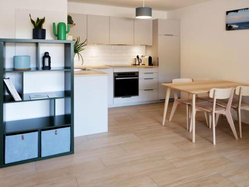 une cuisine et une salle à manger avec une table et des chaises dans l'établissement Appartement neuf T2 50m2 calme et spacieux près de la plage et golf avec grand balcon privé, à Seignosse