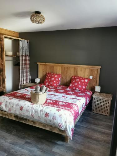 une chambre avec un lit avec des oreillers rouges dans l'établissement Le Cocon de Litia, à Cornimont