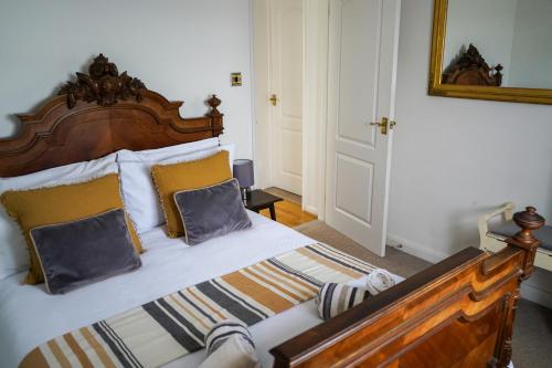 a bedroom with a large wooden bed with two pillows at Waterside Park Annex in Kingsbridge