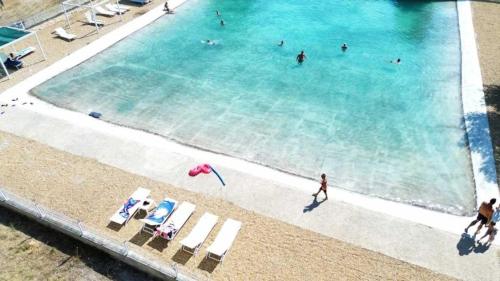 un groupe de personnes se baignant dans une grande piscine dans l'établissement Camping 3 étoiles - Piscine - ccbaehg, à Mézel