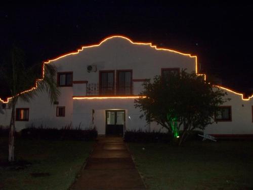a white house with lights on it at night at Hotel La Posta del Dayman in Termas del Daymán