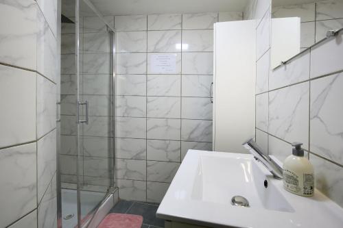 a white bathroom with a sink and a shower at " Loutrein Lodge " Hyper Centre - Calme - WiFi in Saint-Girons
