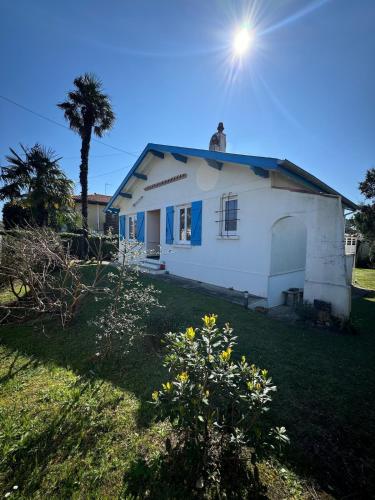 une maison blanche avec un arbre dans la cour dans l'établissement Villa Dziunia Townhouse with garden, à Tarnos