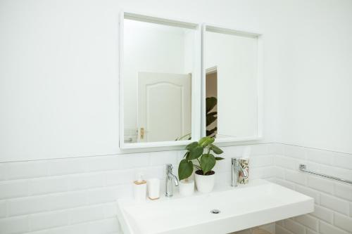 a white bathroom with a sink and a mirror at 55 Tulbagh events and wedding venue in Kempton Park