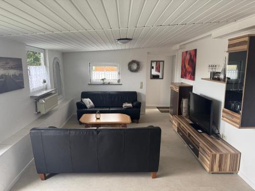 a living room with a black couch and a tv at Ferienwohnung Römerbrücke in Trier