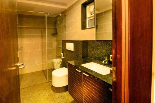 une salle de bain avec toilettes, lavabo et douche dans l'établissement Horizon Heights Apartment, à Coimbatore