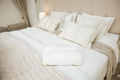 a white bed with white blankets and pillows on it at 55 Tulbagh events and wedding venue in Kempton Park