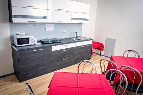 a kitchen with a microwave and red tables and chairs at Hotel Zimní stadion Náchod in Náchod