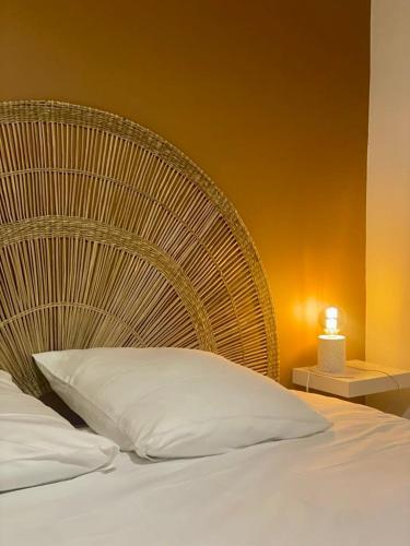 une chambre avec un grand lit avec une tête de lit en rotin dans l'établissement Appartement cosy en centre-ville, à Calais