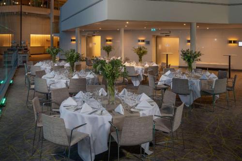 a banquet hall with tables and chairs with white table cloth at Hilton London Heathrow Airport in Hillingdon