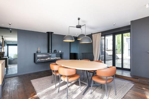 une cuisine et une salle à manger avec une table et des chaises dans l'établissement Ermitage - Magnificent Villa with Panoramic View Saint-Cyr-au-Mont-d'Or, à Saint-Cyr-au-Mont-dʼOr