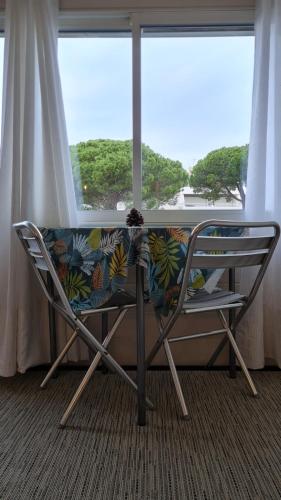 une chaise assise devant une grande fenêtre dans l'établissement le 28 vue mer, au Grau-du-Roi