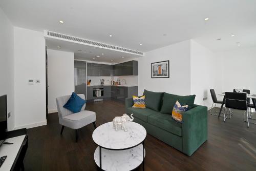 a living room with a green couch and a table at Access Tower Hill in London