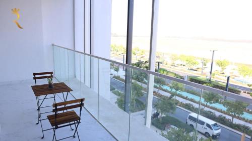 a balcony with a table and chairs and a view of a street at Oasis Luxe 1BR - Stylish Luxury Stay Near Masdar Park & City Centre Masdar in Abu Dhabi
