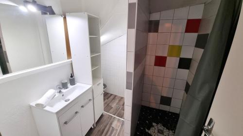 une salle de bain blanche avec un lavabo et une douche dans l'établissement L'Emile - Près des Halles - Parking privé, à Pau