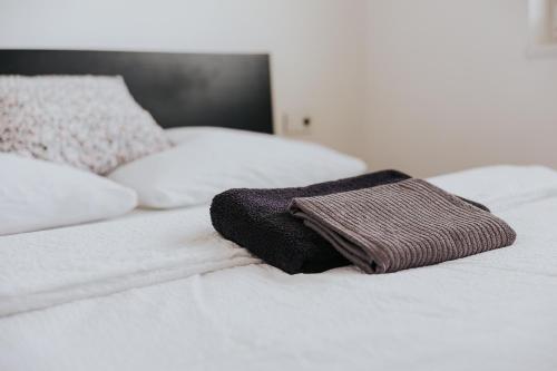 a brown towel sitting on top of a white bed at Valdštejn - pohoda v Českém ráji in Jičín