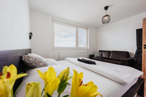 a bedroom with two beds and a couch and yellow flowers at Valdštejn - pohoda v Českém ráji in Jičín