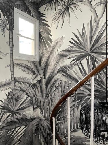un escalier orné d'une fresque murale représentant des palmiers. dans l'établissement Charming studio, à Paris