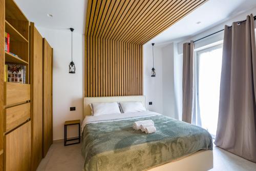 a bedroom with a bed and a large window at Gatto Matto in Brolo