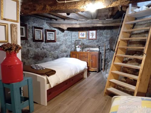 a bedroom with a bed and a wooden staircase at Casa de Aldeia Vale do Mondego in Guarda