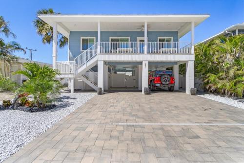 a blue house with a porch and a car parked in front at Welcome to Mermaid Bay Vacation Rental - 261 Delmar home in Fort Myers Beach