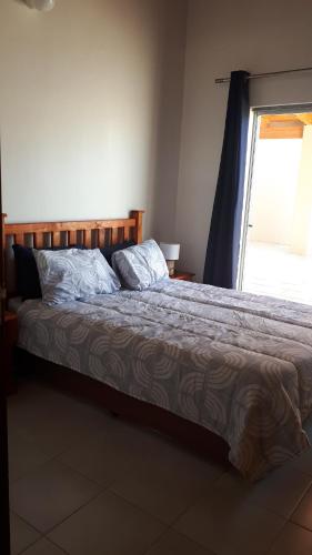 a bed sitting in a bedroom with a window at 1801 on Brandberg in Hentiesbaai