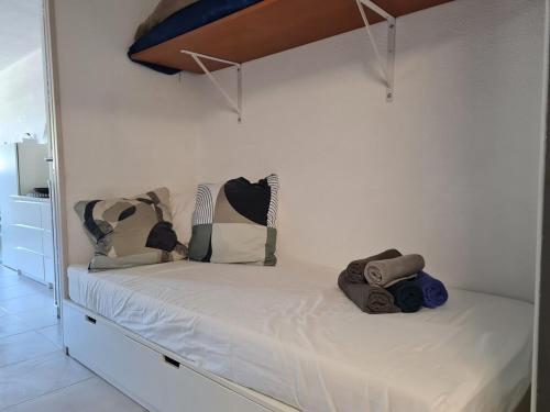 - un lit blanc avec des oreillers dans l'établissement le 28 vue mer, au Grau-du-Roi