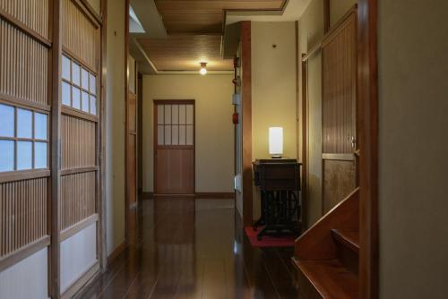 an empty hallway with a door and a lamp in a room at 湯治宿かふね in Yugawara