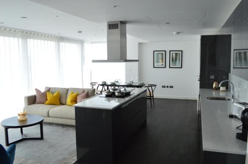 a kitchen and a living room with a couch at Access Tower Hill in London