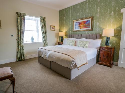 a bedroom with a large bed and a window at Royal Artillery Cottage - Culzean Castle in Maybole