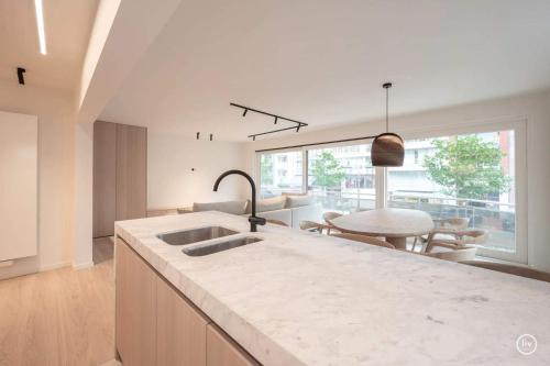a kitchen with a sink and a large window at Stylish apartment in Knokke - Balcony city view in Knokke-Heist