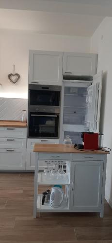 a kitchen with white cabinets and a wooden table at Canaletto apartment con parcheggio in Dolo