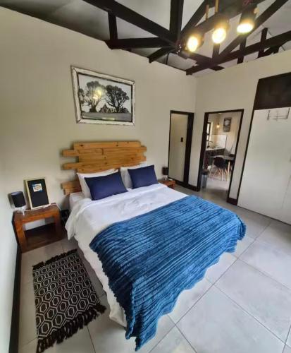 a bedroom with a large bed with a blue blanket at The mighty Sleep in Pretoria